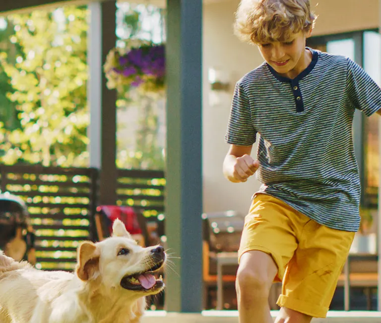 Boy playing with dog in the backyard | Active Pest Control serving Georgia