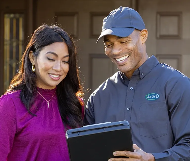Active Pest Control technician with customer outside residential home