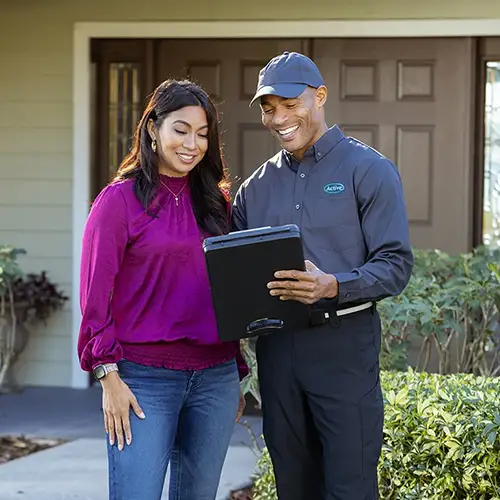 Pest control technician with customer in front of their house - Keep pests away form your home with Active Pest Control in GA