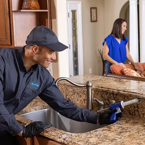 Pest control technician treating a kitchen for ants - Keep pests away form your kitchen with Active Pest Control in GA