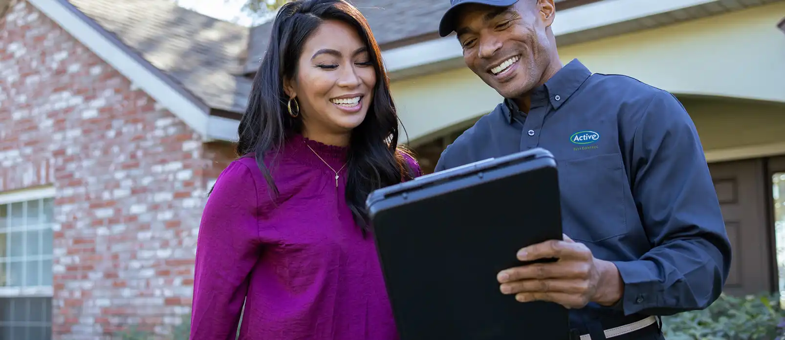 Pest control technician with a customer outside their home - Keep pests away with Active Pest Control in GA