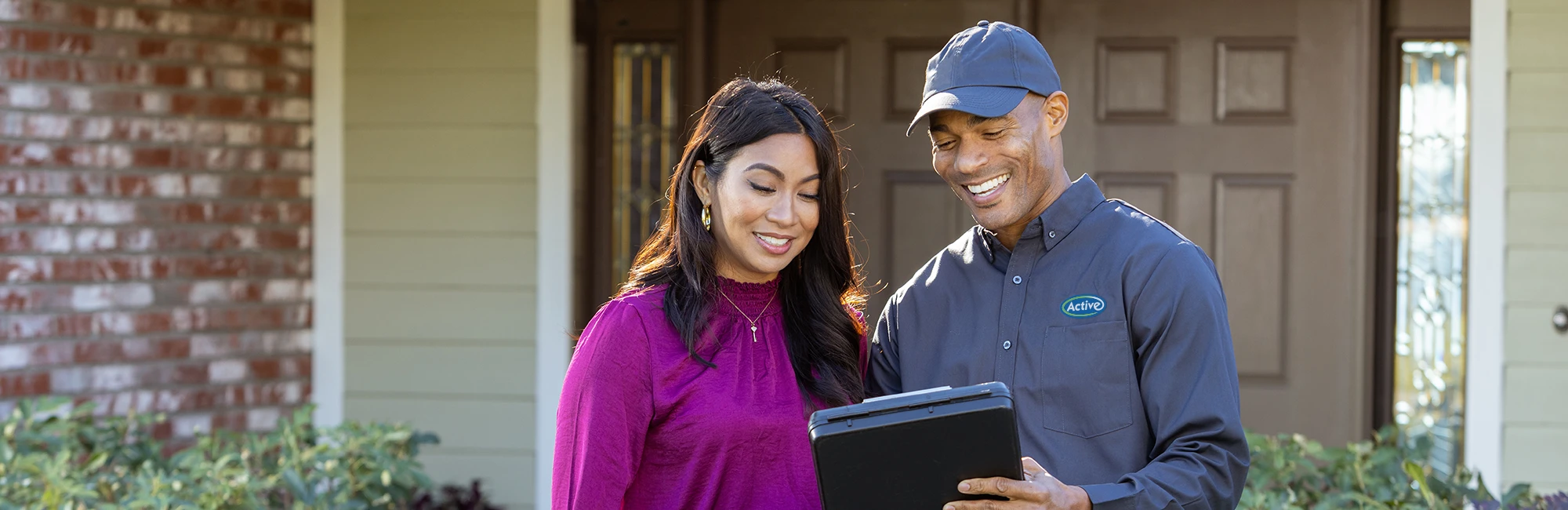 Pest control technician with a customer in front of their home - Keep pests away with Active Pest Control in GA