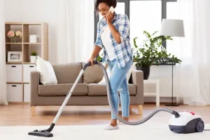 Woman vacuuming rug while speaking on the phone | Active Pest Control serving Calhoun, GA