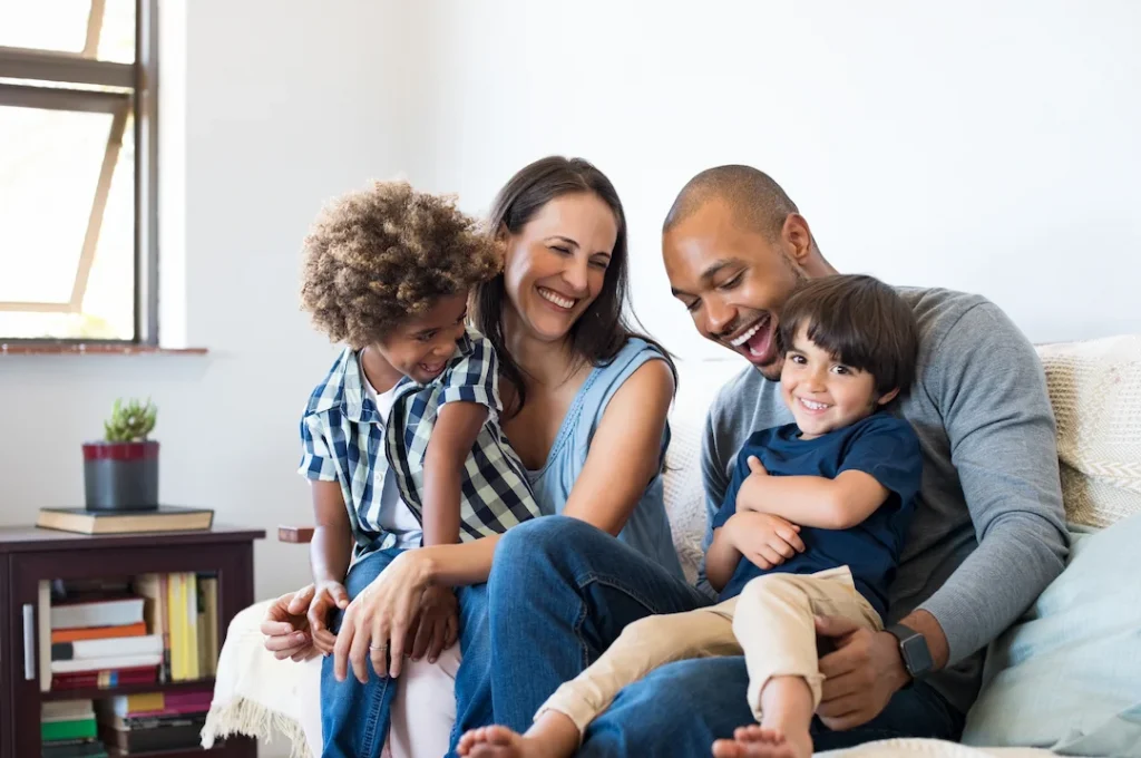 Family of four on a couch smiling - Keep pests away from your home with Active Pest Control in GA