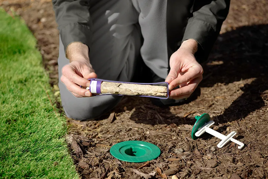 Pest control technician showing a termite bait station